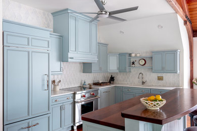 Inspiration for a timeless u-shaped medium tone wood floor and brown floor kitchen remodel in Boston with an undermount sink, recessed-panel cabinets, blue cabinets, gray backsplash, stainless steel appliances, an island and white countertops