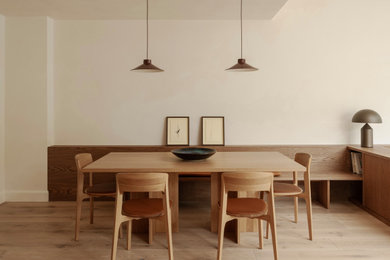 This is an example of a medium sized contemporary open plan dining room in Dublin with white walls, light hardwood flooring and beige floors.