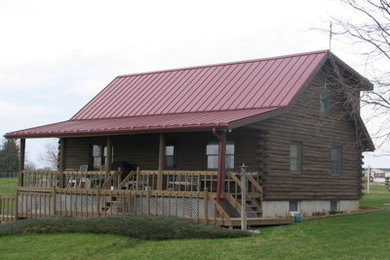 Country two-storey brown exterior in Other with wood siding and a gable roof.
