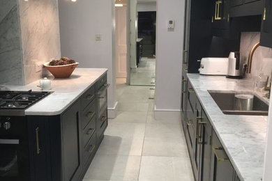 Photo of a medium sized contemporary enclosed kitchen in London with ceramic flooring and an island.