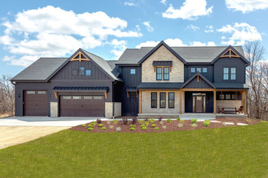 Example of a mid-sized transitional black two-story mixed siding and board and batten exterior home design in Milwaukee with a shingle roof and a gray roof