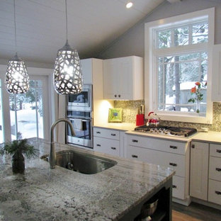 Mid-sized craftsman kitchen pantry ideas - Mid-sized arts and crafts vinyl floor kitchen pantry photo in Grand Rapids with a single-bowl sink, shaker cabinets, white cabinets, granite countertops, multicolored backsplash, glass sheet backsplash, stainless steel appliances and an island