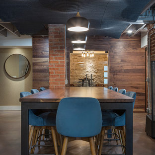 Design ideas for a medium sized rustic walk-out basement in Kansas City with concrete flooring, a wood burning stove and brown floors.