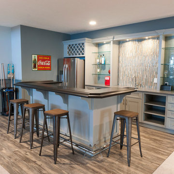 Basement Bar with Island, Luxury Vinyl Flooring, and Corian Countertops