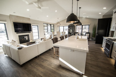 Inspiration for a mid-sized transitional open concept brown floor and laminate floor family room remodel in Cedar Rapids with gray walls, a standard fireplace, a metal fireplace and a wall-mounted tv