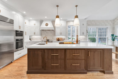Inspiration for a transitional medium tone wood floor eat-in kitchen remodel in New York with an undermount sink, quartz countertops, stainless steel appliances and an island