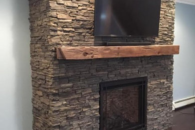 Living room - mid-sized traditional open concept medium tone wood floor living room idea in New York with blue walls, a standard fireplace, a stone fireplace and a wall-mounted tv