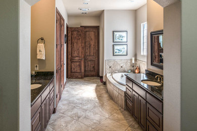 Bathroom - mid-sized traditional master beige tile and ceramic tile porcelain tile bathroom idea in Austin with shaker cabinets, dark wood cabinets, white walls, an undermount sink and granite countertops