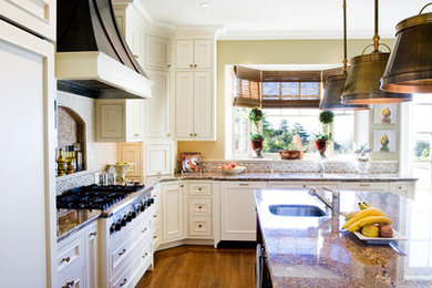 Large elegant l-shaped medium tone wood floor and brown floor eat-in kitchen photo in San Francisco with an undermount sink, beaded inset cabinets, white cabinets, granite countertops, multicolored backsplash, cement tile backsplash, stainless steel appliances and an island