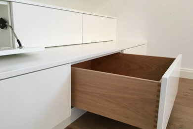 Modernes Ankleidezimmer mit weißen Schränken und braunem Holzboden in Düsseldorf