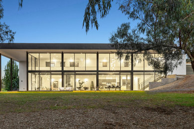 Großes, Zweistöckiges Modernes Einfamilienhaus mit Betonfassade, weißer Fassadenfarbe, Flachdach, Blechdach und schwarzem Dach in Melbourne