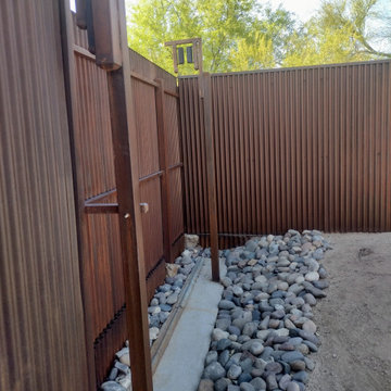 Corrugated Metal Fence with Lighted Stucco Columns Rolling  gate