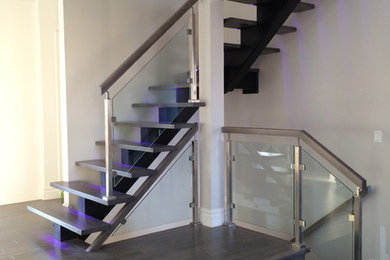 This is an example of a mid-sized modern wood l-shaped staircase in Montreal with open risers.
