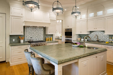 Inspiration for an expansive traditional u-shaped separate kitchen in San Diego with a drop-in sink, beaded inset cabinets, white cabinets, granite benchtops, green splashback, mosaic tile splashback, stainless steel appliances, medium hardwood floors, with island and brown floor.