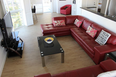 Photo of a mid-sized beach style living room in Gold Coast - Tweed with white walls and vinyl floors.