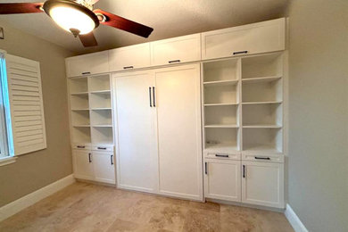 Inspiration for a mid-sized contemporary freestanding desk travertine floor home office library remodel in Miami with beige walls