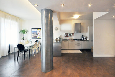 Ispirazione per una grande cucina minimal con lavello integrato, ante lisce, ante bianche, top in acciaio inossidabile, paraspruzzi bianco, paraspruzzi in gres porcellanato, elettrodomestici bianchi, pavimento in gres porcellanato, penisola e pavimento marrone