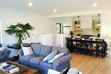 Esempio di una sala da pranzo aperta verso il soggiorno costiera di medie dimensioni con pavimento in legno massello medio e pavimento marrone