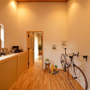 他の地域の片開きドア北欧スタイルのおしゃれな玄関ホール (ベージュの壁、淡色無垢フローリング、茶色い床) の写真