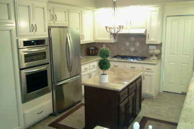 Enclosed kitchen - mid-sized transitional l-shaped ceramic tile enclosed kitchen idea in Los Angeles with recessed-panel cabinets, white cabinets, granite countertops, brown backsplash, ceramic backsplash, stainless steel appliances and an island