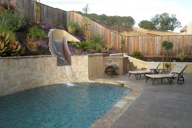 Photo of a traditional backyard custom-shaped pool in Sacramento with natural stone pavers.
