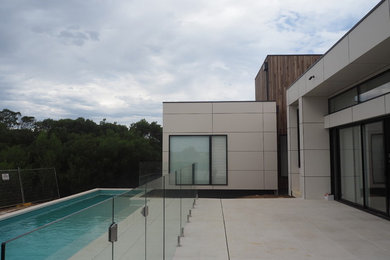 This is an example of a mid-sized modern backyard rectangular lap pool in Geelong with a pool house and concrete pavers.