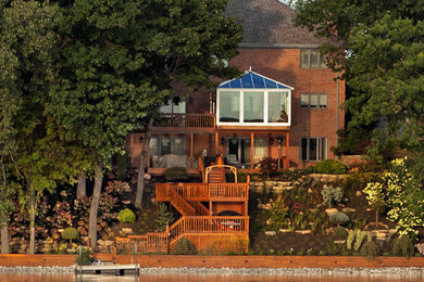 Design ideas for a huge coastal shade backyard stone retaining wall landscape in Chicago for summer.