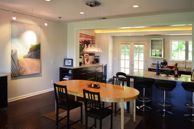 Eat-in kitchen - mid-sized contemporary galley dark wood floor eat-in kitchen idea in Other with an undermount sink, flat-panel cabinets, black cabinets, granite countertops, stone slab backsplash, stainless steel appliances and a peninsula