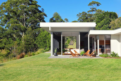 Inspiration for a large one-storey white house exterior in Sunshine Coast with a flat roof and a metal roof.