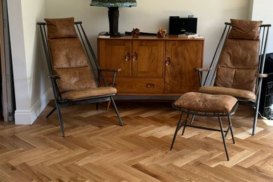 This is an example of a medium sized eclectic living room in Sussex with medium hardwood flooring.