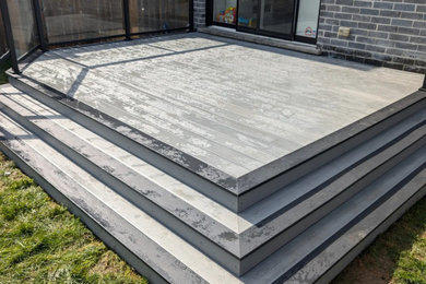 Deck - mid-sized modern backyard ground level metal railing deck idea in Toronto with no cover