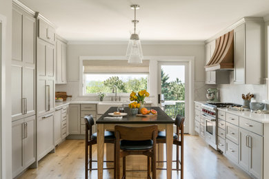 Large transitional u-shaped medium tone wood floor eat-in kitchen photo in Burlington with a farmhouse sink, shaker cabinets, beige cabinets, soapstone countertops, beige backsplash, quartz backsplash, paneled appliances, an island and black countertops