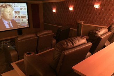 Modelo de cine en casa cerrado clásico de tamaño medio con paredes rojas, moqueta, pantalla de proyección y suelo rojo