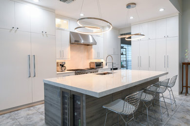 Large l-shaped porcelain tile and multicolored floor eat-in kitchen photo in Tampa with an undermount sink, flat-panel cabinets, medium tone wood cabinets, quartz countertops, beige backsplash, ceramic backsplash, stainless steel appliances, an island and beige countertops