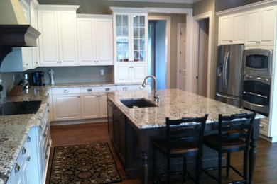 Elegant u-shaped open concept kitchen photo in Indianapolis with an undermount sink, raised-panel cabinets, white cabinets and stainless steel appliances