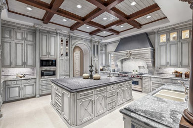 Large elegant u-shaped porcelain tile enclosed kitchen photo in Dallas with a double-bowl sink, raised-panel cabinets, white cabinets, marble countertops, white backsplash, marble backsplash, stainless steel appliances and an island