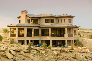 Example of a large tuscan brown two-story mixed siding house exterior design in Other with a hip roof and a shingle roof