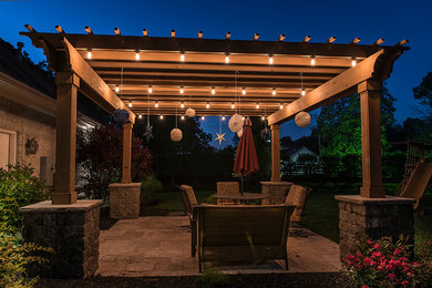 Design ideas for a mid-sized arts and crafts backyard patio in Indianapolis with concrete pavers and a pergola.