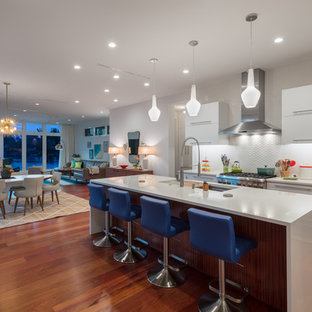 Large contemporary open concept kitchen pictures - Large trendy u-shaped brown floor and medium tone wood floor open concept kitchen photo in Tampa with a double-bowl sink, flat-panel cabinets, white cabinets, white backsplash, porcelain backsplash, an island, stainless steel appliances and quartz countertops