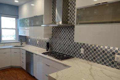 Enclosed kitchen - small modern galley medium tone wood floor and orange floor enclosed kitchen idea in DC Metro with an undermount sink, flat-panel cabinets, white cabinets, quartz countertops, blue backsplash, cement tile backsplash, stainless steel appliances, a peninsula and white countertops