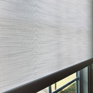 Cette image montre un hall d'entrée bohème avec un mur gris, un sol en bambou, une porte simple, une porte blanche et un sol marron.