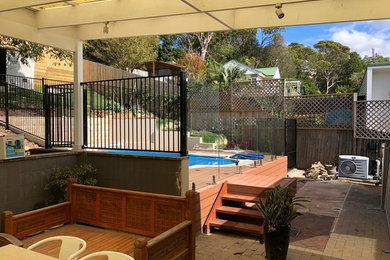 Aménagement d'une grande piscine arrière contemporaine rectangle avec une terrasse en bois.