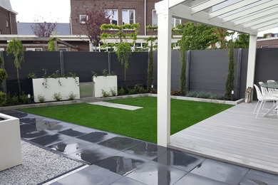 Photo of a small modern partial sun backyard landscaping in Amsterdam with decking for spring.