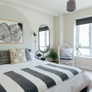 Calming guest bedroom with painted arch headboard