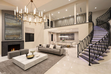 Example of a large trendy formal and open concept porcelain tile and gray floor living room design in Los Angeles with beige walls, a standard fireplace, a stone fireplace and no tv