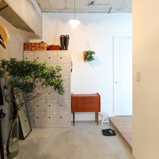 東京23区のラスティックスタイルのおしゃれな玄関 (マルチカラーの壁、コンクリートの床、グレーの床) の写真