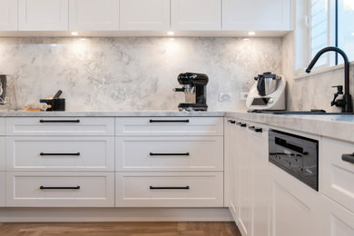 Design ideas for a contemporary kitchen in Adelaide with shaker cabinets, white cabinets, grey splashback, stone slab splashback, light hardwood floors, with island and grey benchtop.