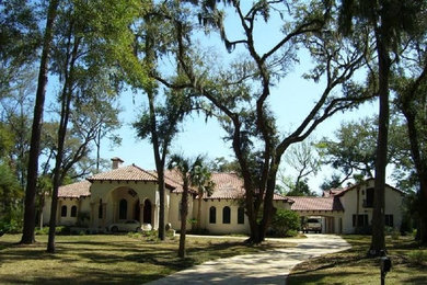 Photo of a large mediterranean one-storey stucco white house exterior in Jacksonville with a hip roof and a tile roof.