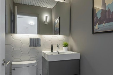 Inspiration for a mid-sized modern beige tile and ceramic tile porcelain tile and gray floor powder room remodel in Chicago with flat-panel cabinets, gray cabinets, a one-piece toilet, gray walls, quartz countertops and white countertops