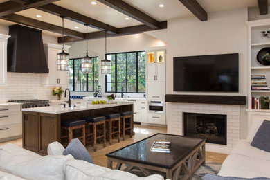 Example of a large transitional ceramic tile, brown floor and exposed beam open concept kitchen design in San Diego with a farmhouse sink, shaker cabinets, white cabinets, quartz countertops, white backsplash, ceramic backsplash, stainless steel appliances, an island and white countertops